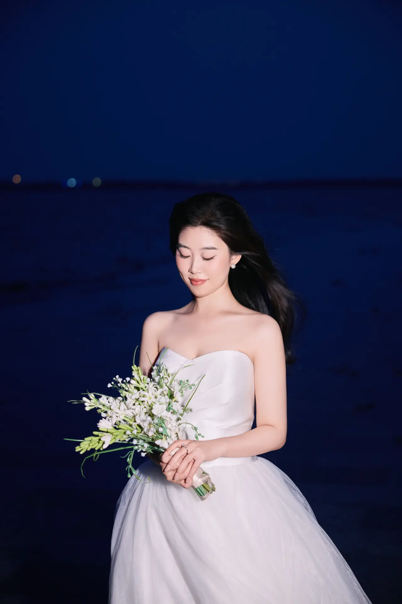 海边夜色中的张晴手捧花束